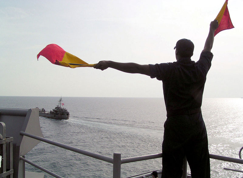 Man Waving Flags For Boat